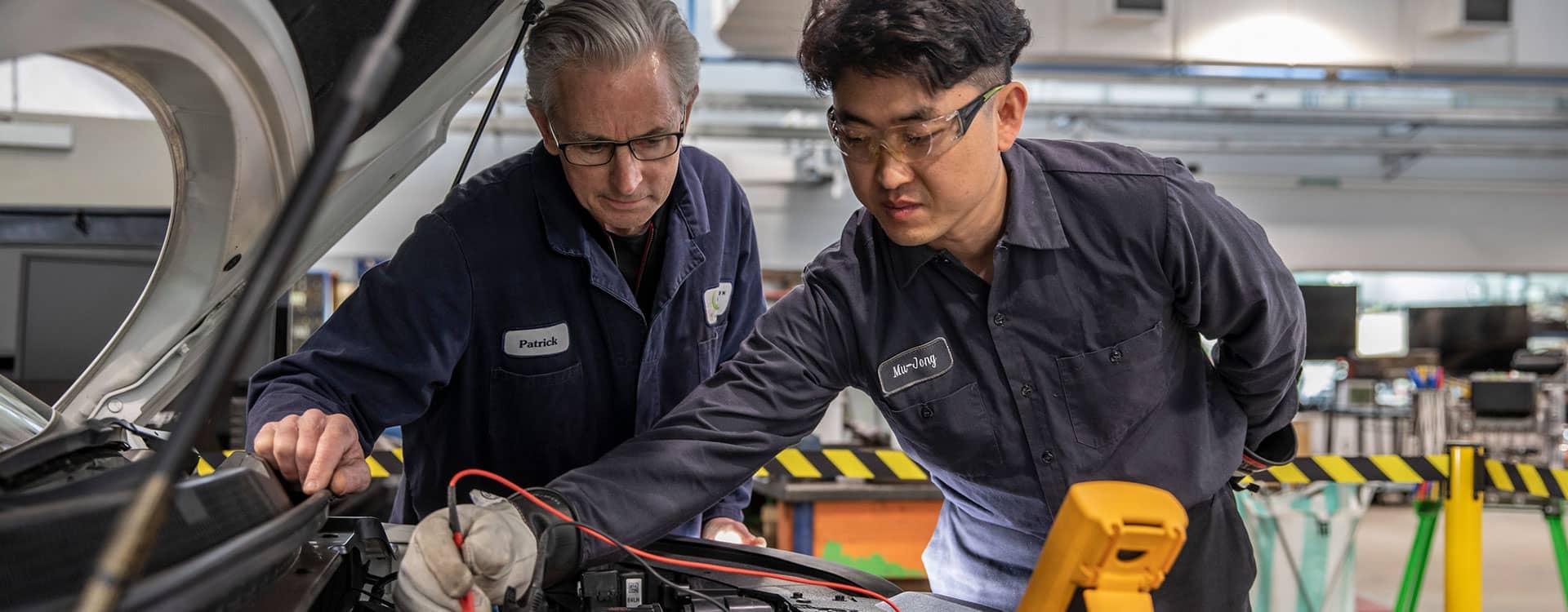 student and teacher working on an engine